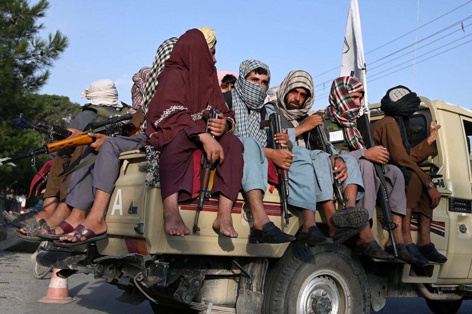 TOPSHOT - Taliban fighters in a vehicle patrol the streets of Kabul on August 23, 2021 as in the capital, the Taliban have enforced some sense of calm in a city long marred by violent crime, with their armed forces patrolling the streets and manning checkpoints. (Photo by Wakil KOHSAR / AFP)
